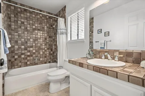 a bathroom with a double vanity sink toilet and shower