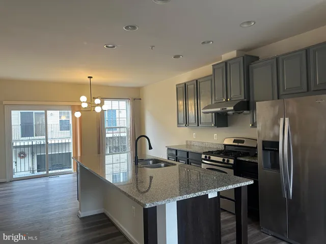 a kitchen with kitchen island a sink appliances and cabinets