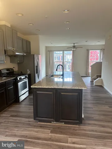 a kitchen with kitchen island granite countertop a stove and a sink