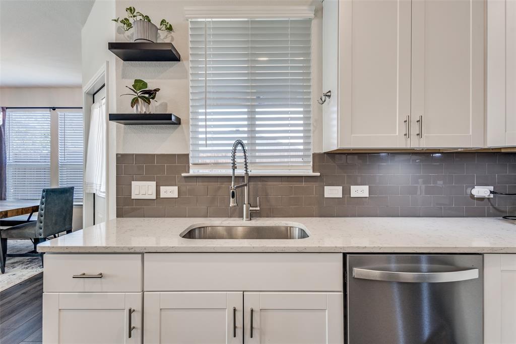 1810 Hummingbird Street Princeton, TX 75407 - Photo 13 of 25 he kitchen showcases timeless white cabinetry, stainless steel appliances, a decorative backsplash, beautiful countertops, and a charming farmhouse sink. A standout window brings in natural light and allows you to keep an eye on the kids or simply open it to chat with family and guests enjoying the backyard.