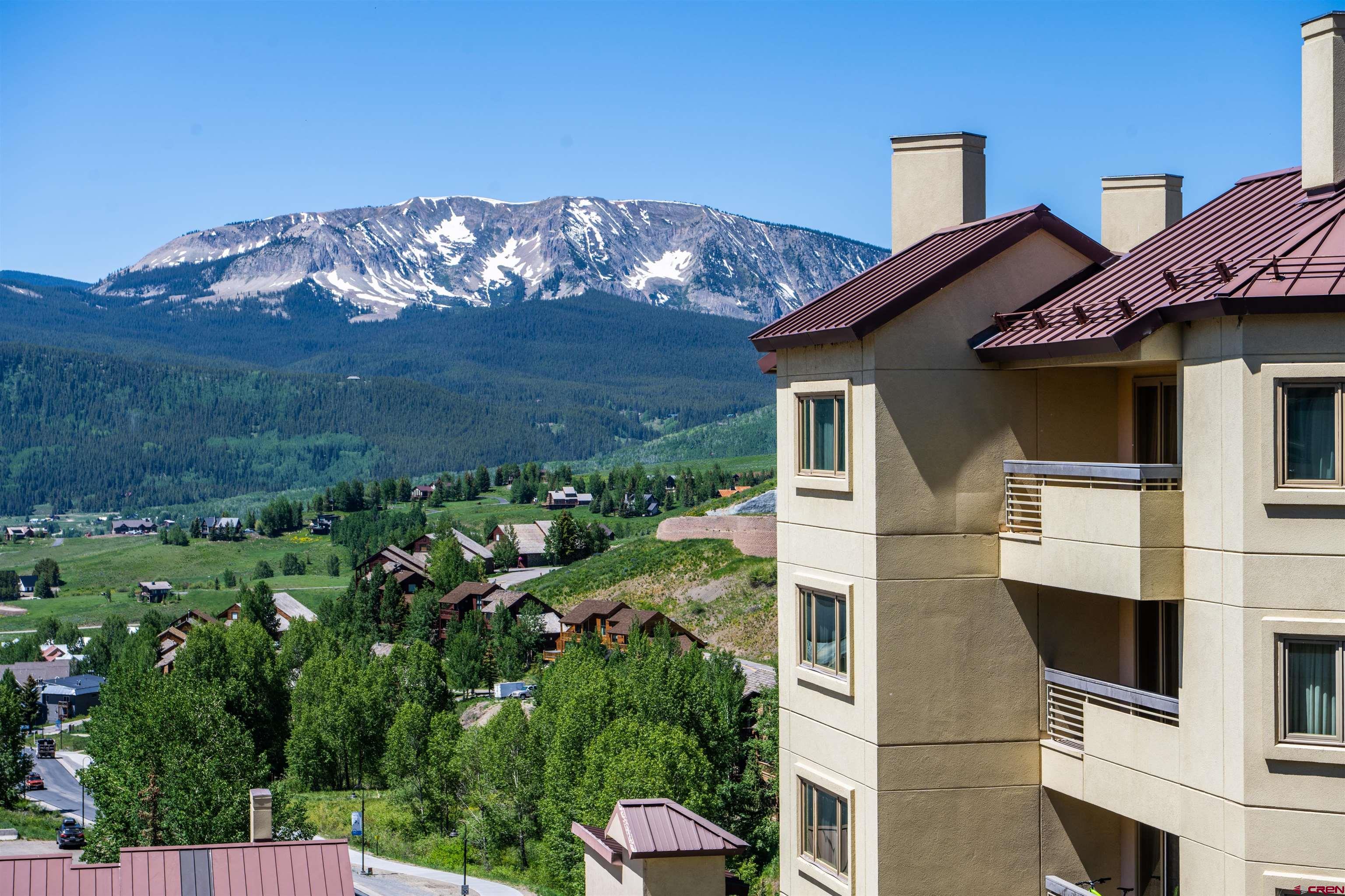 500 Gothic Road, Unit 533 Crested Butte, CO 81225 - Photo 15 of 19 a view of a white house with a big yard and large tree