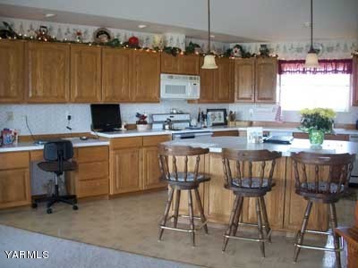12216 West Barrett Road Yakima, WA 98908 - Photo 9 of 21 a kitchen with a sink window and cabinets
