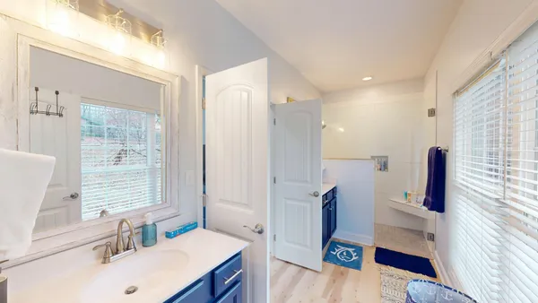 a bathroom with a sink vanity mirror and a bathtub