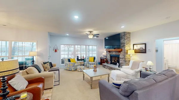 a living room with fireplace furniture and a large window