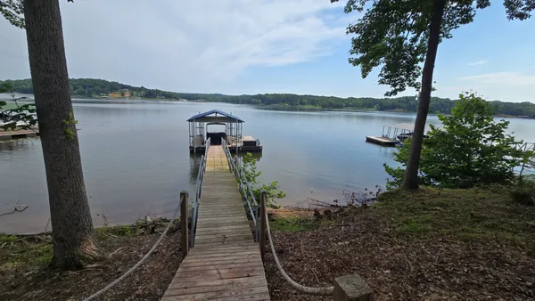 a view of a lake with a floor to ceiling window and wooden fence