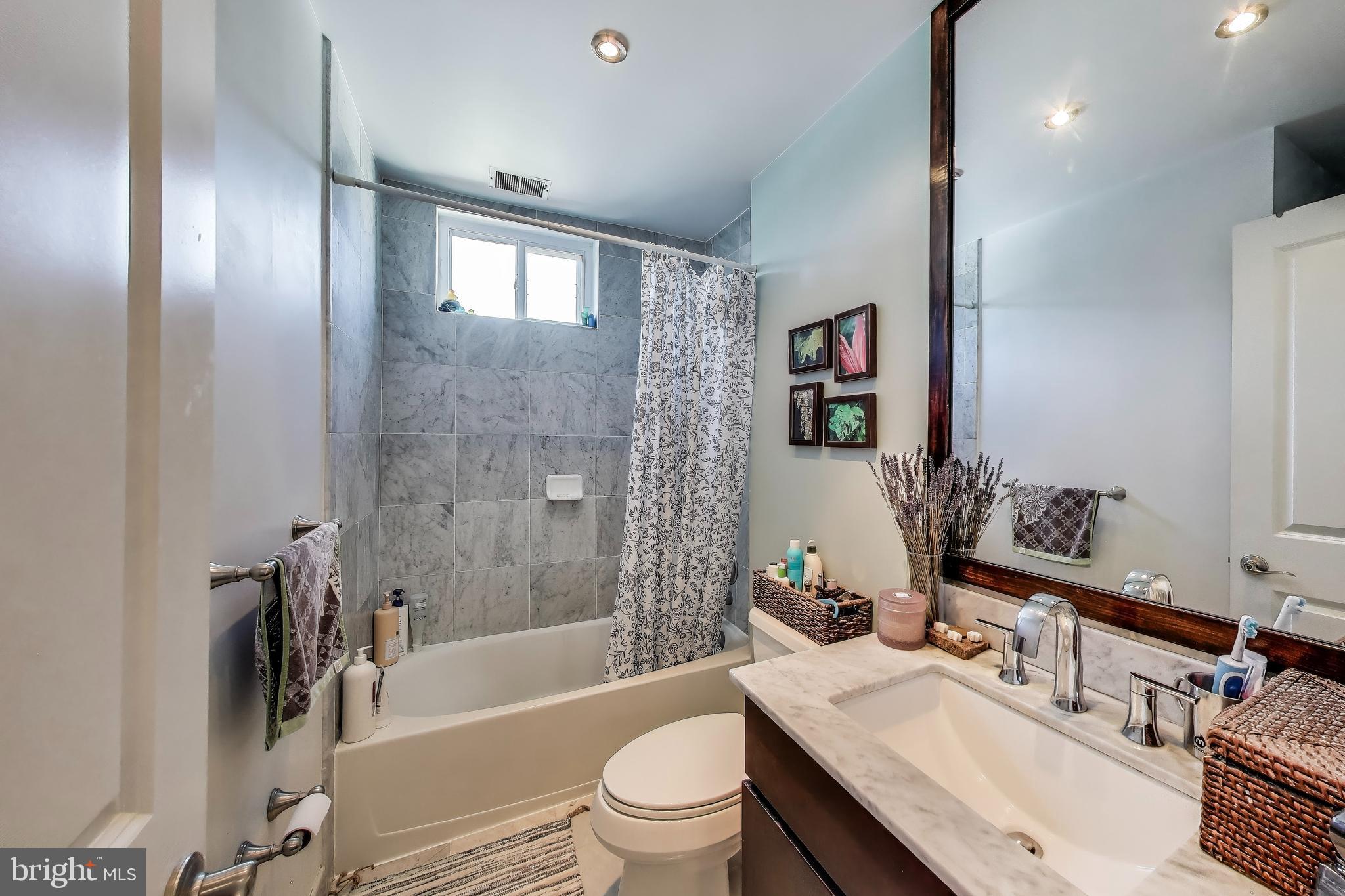 1461 Girard Street Northwest, Unit 400 Washington, DC 20009 - Photo 11 of 13 a bathroom with a sink a toilet and shower