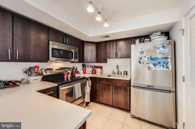 a kitchen with stainless steel appliances a refrigerator sink and microwave