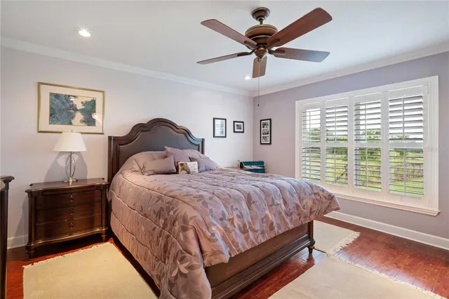 a bedroom with a bed a dresser and a chandelier