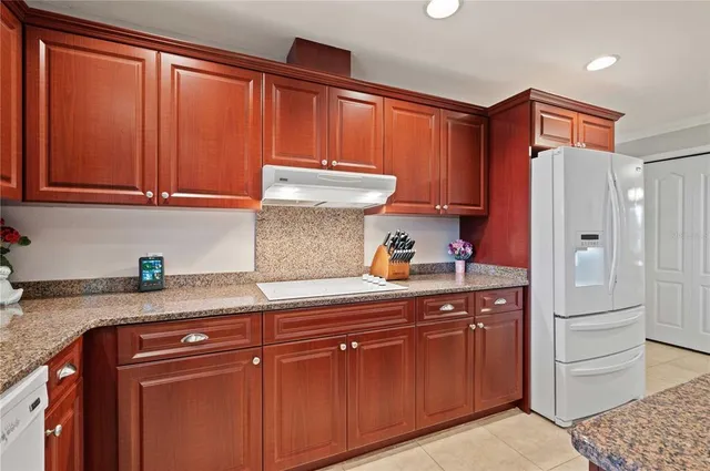 a kitchen with granite countertop wooden cabinets and a sink