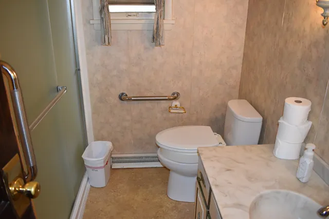 a toilet sitting in a bathroom next to a wooden wall