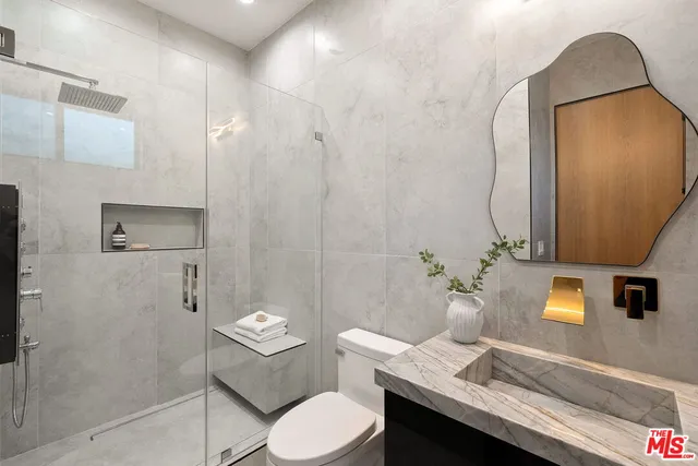 a spacious bedroom with a bed and a painting on the wall