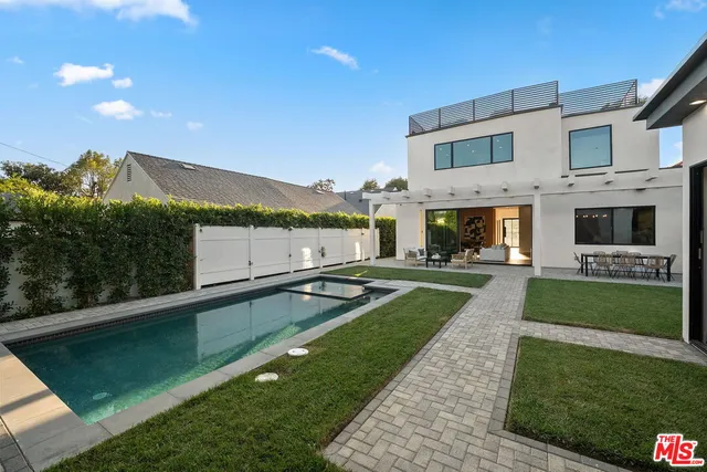 a view of a house with a swimming pool and a yard
