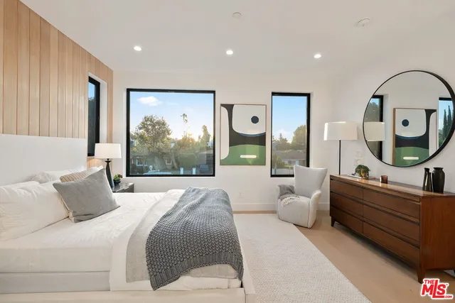 a bedroom with a bed and a painting on the wall