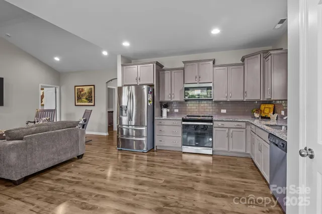 a kitchen with stainless steel appliances a refrigerator sink and stove