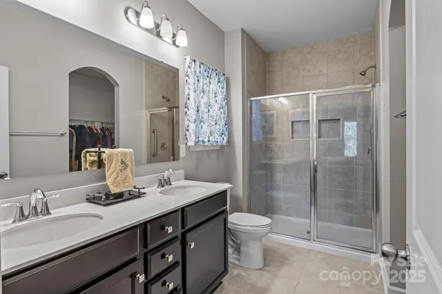 a bathroom with a double vanity sink toilet and shower