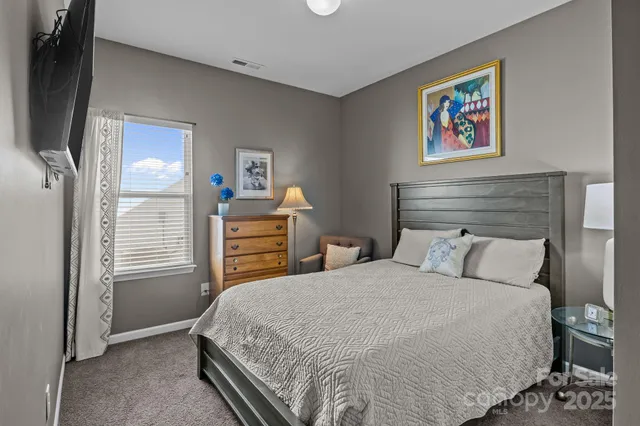 a bedroom with a bed and a painting on the wall