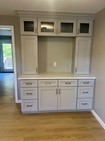 a view of an empty room with cabinet and mirror