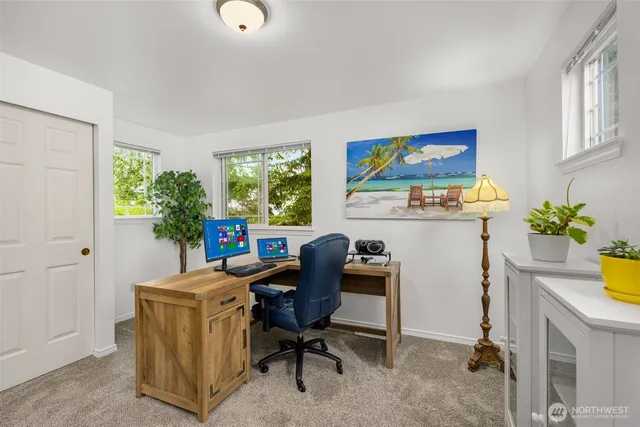 a view of a workspace with furniture and a window