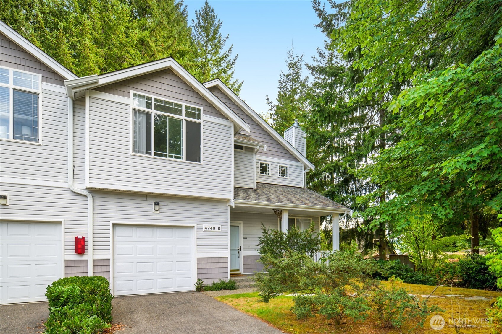 4748 Lakeshore Lane Southeast, Unit B Olympia, WA 98513 - Photo 2 of 31 a front view of a house with a yard and garage