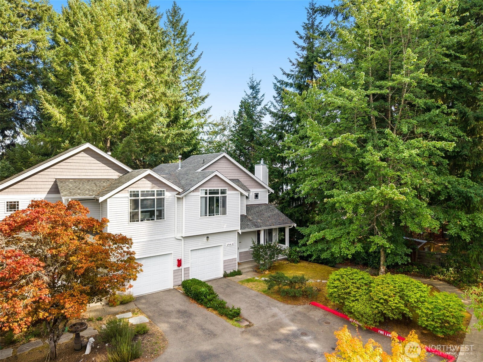 4748 Lakeshore Lane Southeast, Unit B Olympia, WA 98513 - Photo 23 of 31 a front view of a house with a yard and garage