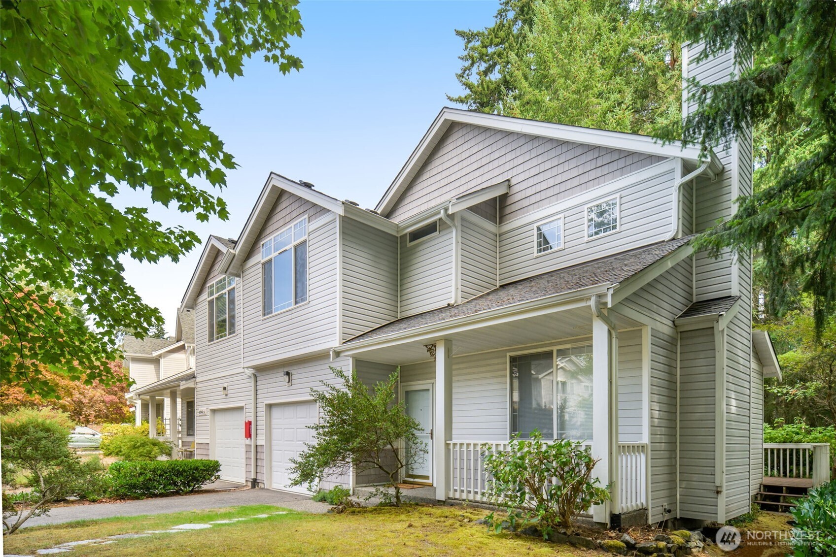 4748 Lakeshore Lane Southeast, Unit B Olympia, WA 98513 - Photo 3 of 31 a view of a white house with a large windows and flower plants
