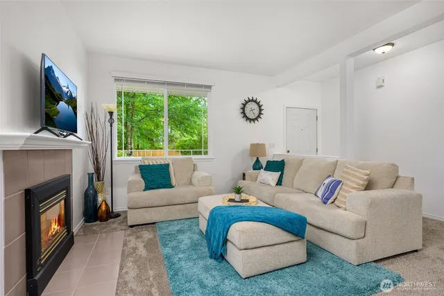 a living room with furniture a flat screen tv and a fireplace