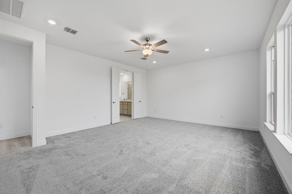 1604 Victory Circle Justin, TX 76247 - Photo 12 of 40 an empty room with a ceiling fan and a window