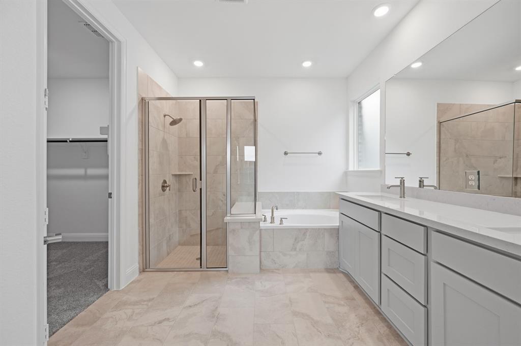 1604 Victory Circle Justin, TX 76247 - Photo 13 of 40 a spacious bathroom with a mirror a shower and a double vanity sink