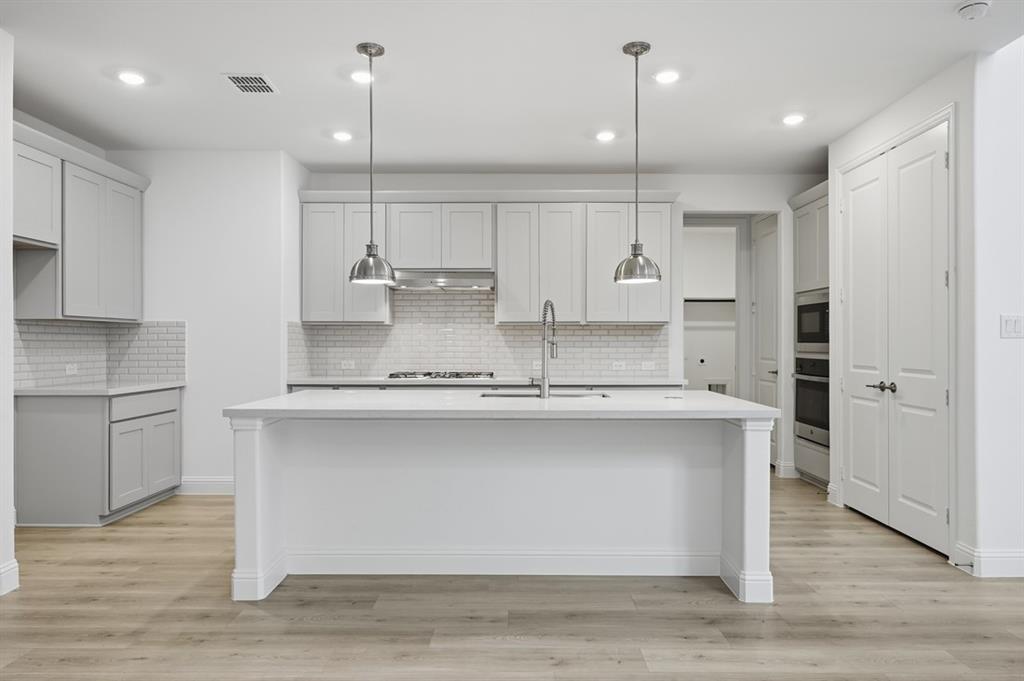 1604 Victory Circle Justin, TX 76247 - Photo 2 of 40 a kitchen with kitchen island a sink stainless steel appliances and cabinets