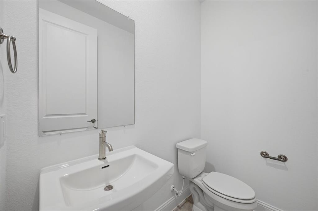 1604 Victory Circle Justin, TX 76247 - Photo 22 of 40 a bathroom with a sink a toilet and vanity