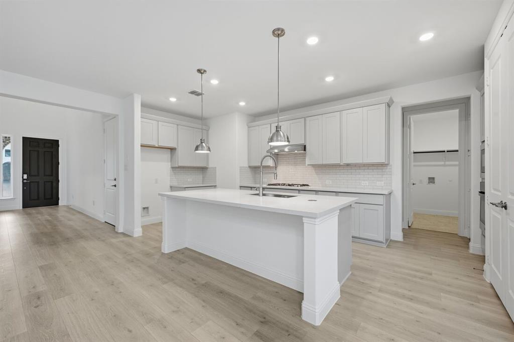 1604 Victory Circle Justin, TX 76247 - Photo 4 of 40 a kitchen with kitchen island a sink stainless steel appliances and cabinets