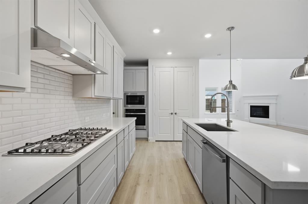 1604 Victory Circle Justin, TX 76247 - Photo 6 of 40 a kitchen with stainless steel appliances a sink stove and refrigerator