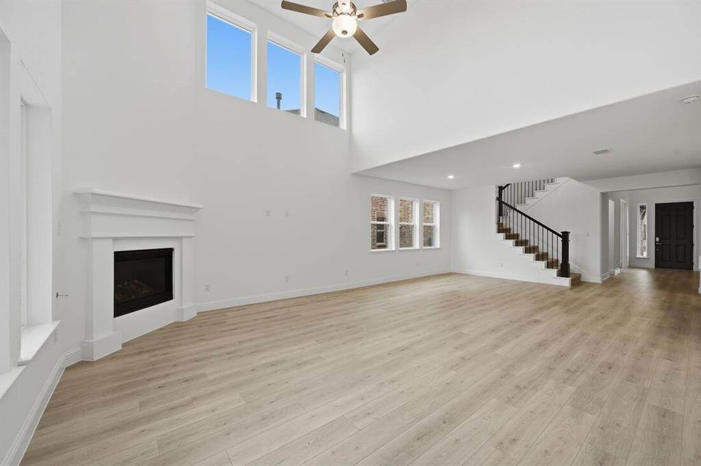 1604 Victory Circle Justin, TX 76247 - Photo 8 of 40 a view of an empty room with wooden floor and a fireplace