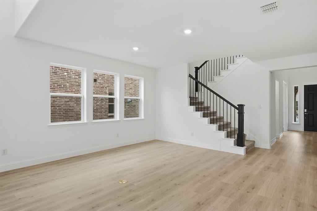 1604 Victory Circle Justin, TX 76247 - Photo 9 of 40 a view of an empty room with wooden floor and a window