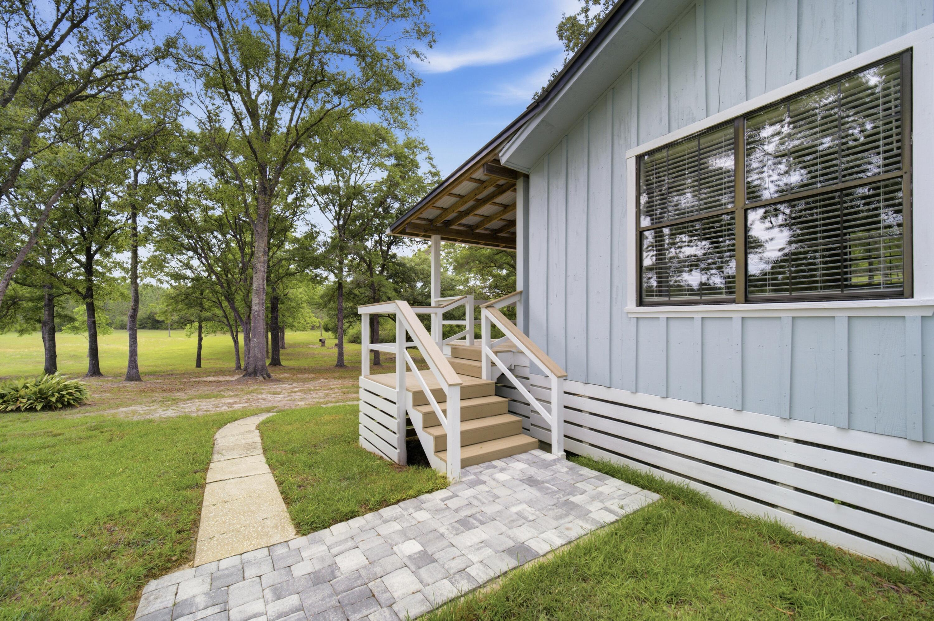 261 Wilkerson Road DeFuniak Springs, FL 32433 - Photo 65 of 76 a view of a house with backyard and a tree