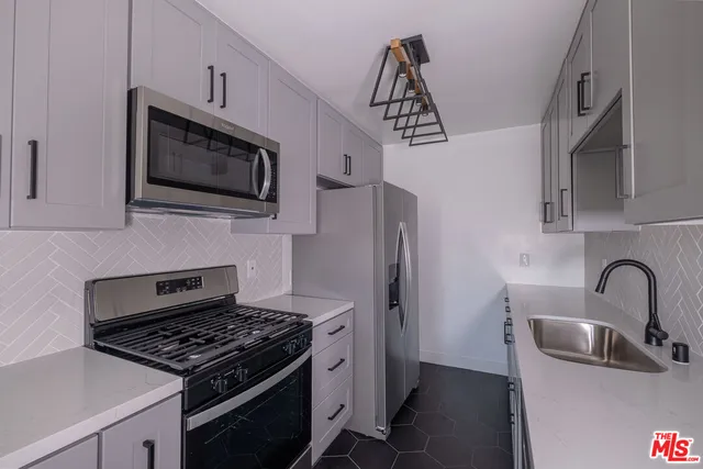 a kitchen with stainless steel appliances kitchen island a stove and a microwave