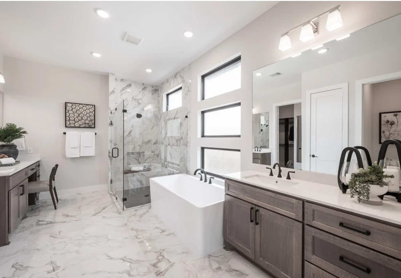 11922 Golden Cove Rosharon, TX 77583 - Photo 7 of 12 a bathroom with a double vanity sink a mirror and a bathtub