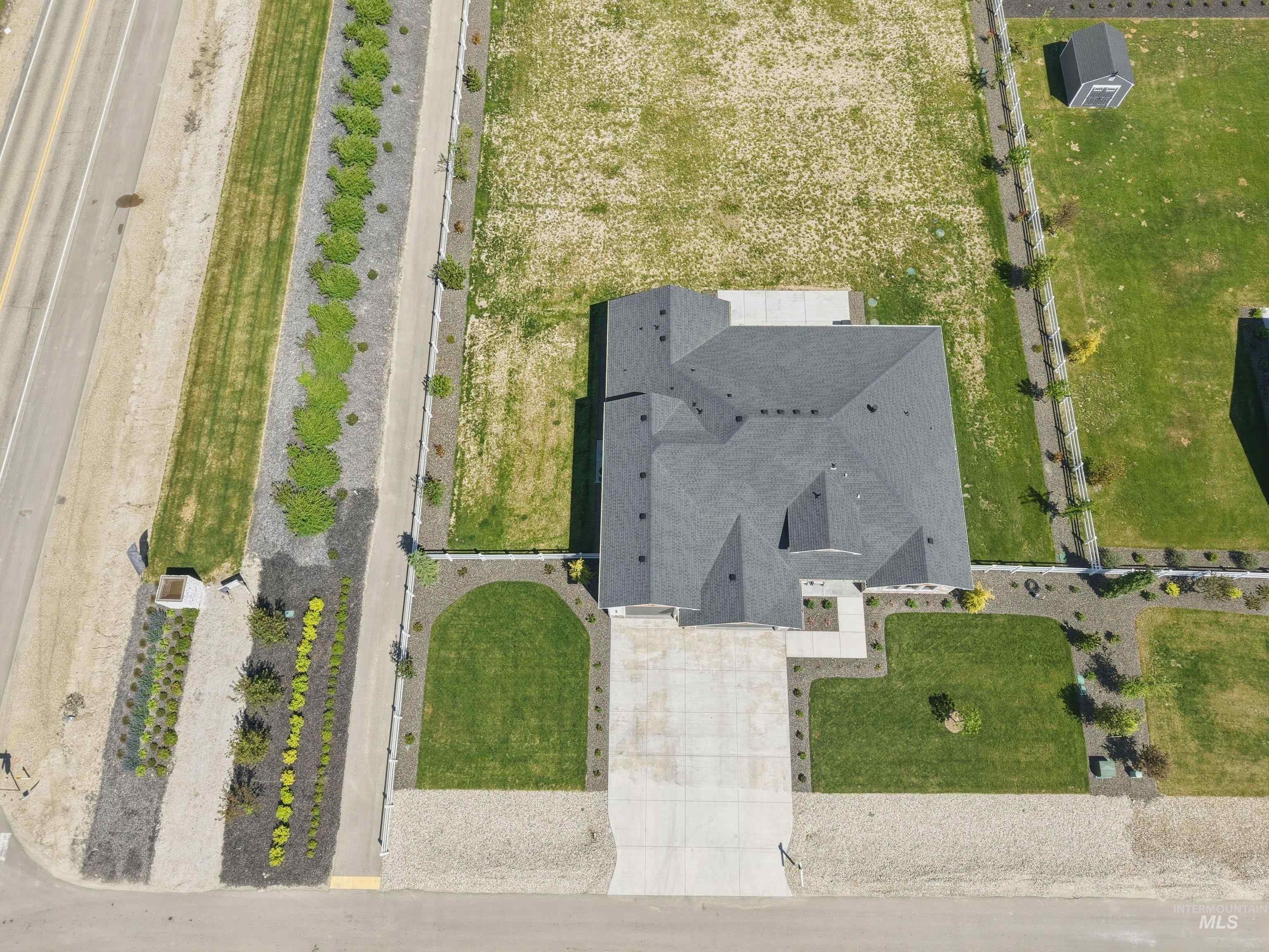 24990 Belgian Way Middleton, ID 83644 - Photo 47 of 50 New construction residence featuring a dark shingle roof, concrete driveway, and established landscaping