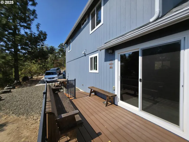 a roof deck with a table and chairs next to a yard