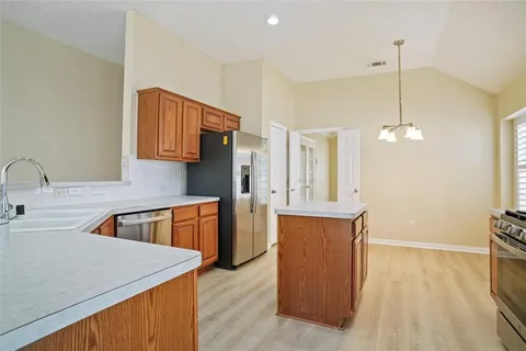 a kitchen with stainless steel appliances granite countertop a sink a refrigerator and a stove