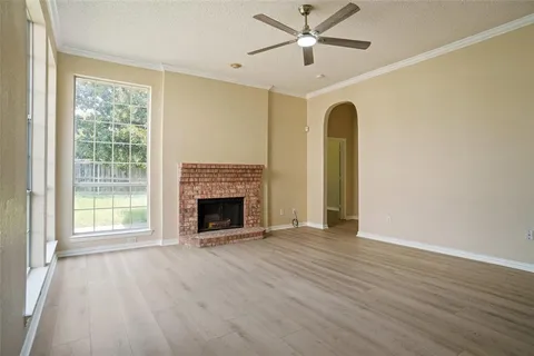 a view of an empty room with a fireplace and a window