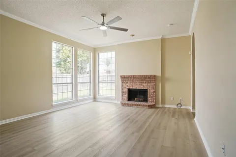 a view of an empty room with a fireplace and a window