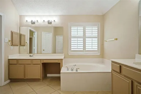 a bathroom with a tub sink and mirror