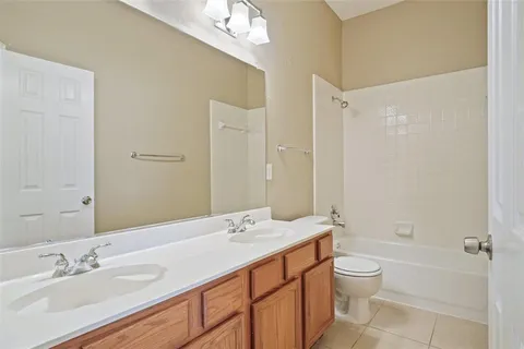 a bathroom with a granite countertop sink a toilet and shower