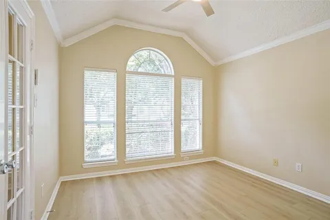 an empty room with wooden floor windows and closet
