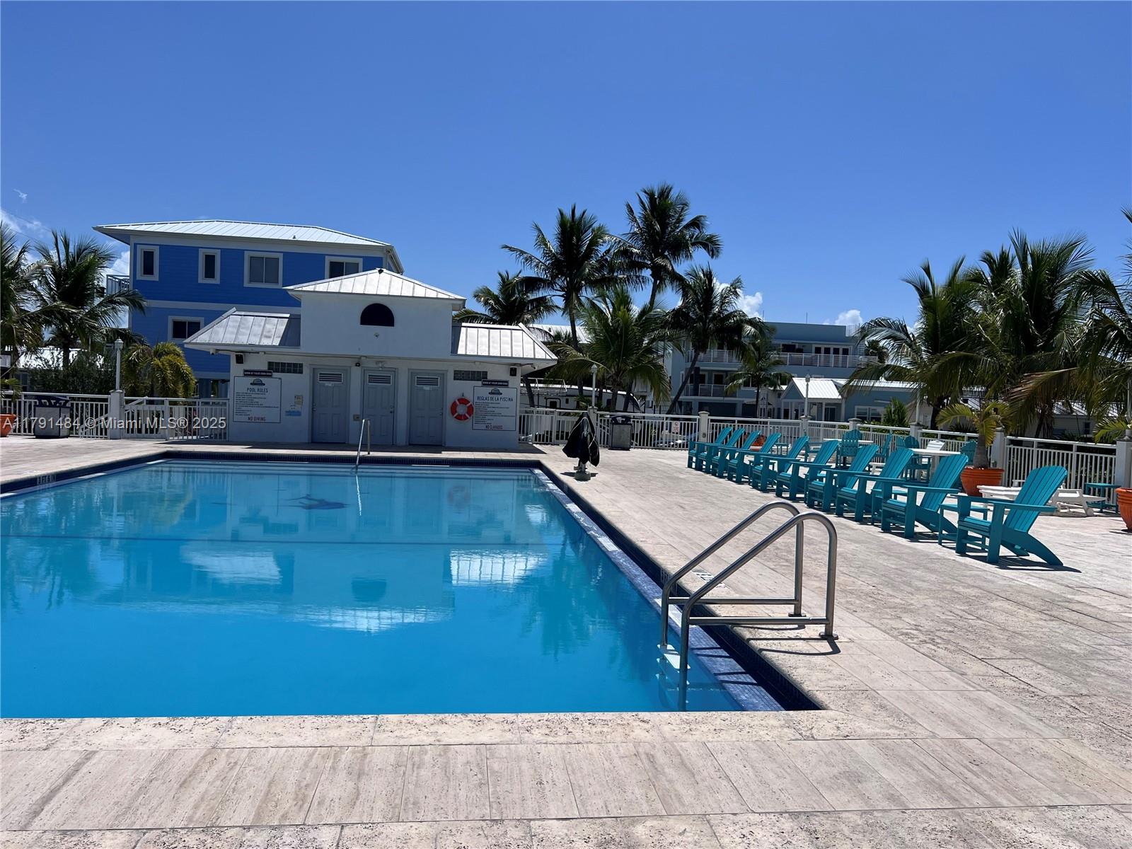 325 Calusa Street, Unit 5 Key Largo, FL 33037 - Photo 19 of 21 a view of a swimming pool with a lounge chairs