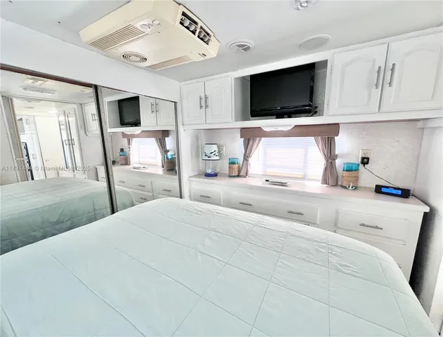 a bedroom with a large bed and a flat screen tv