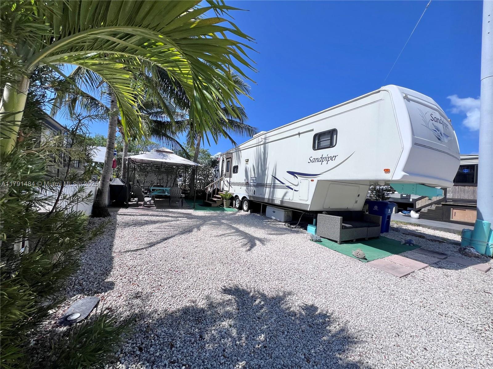 325 Calusa Street, Unit 5 Key Largo, FL 33037 - Photo 9 of 21 a view of a white house with a large trees