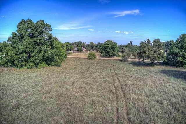 a view of a dirt road with a building in the background