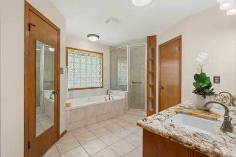 a spacious bathroom with a granite countertop tub sink and shower